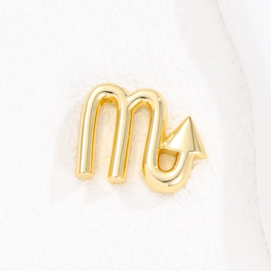 Polished gold Scorpio zodiac balloon pendant on a white textured minimalist background