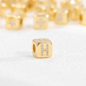 Makroaufnahme des 18k vergoldeten Würfelanhängers mit Zirkonia-Buchstabe H im Detail