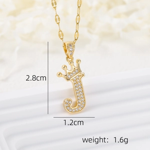 Macro detail of 18k gold plated crown letter J pendant with micro-pave cubic zirconia