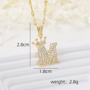 Macro view of 18k gold plated letter M pendant with crown and zircon stones