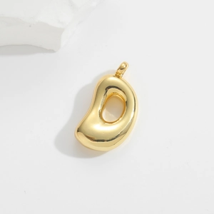 Detail shot of a golden balloon-style alphabet D pendant with a mirror finish