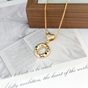 Macro detail of 18K gold-plated necklace featuring a multi-colored zircon heart pendant