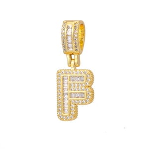 Macro view of crystal letter F pendant with 18k gold plating and baguette zircon stones