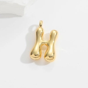 Macro shot of 3D puffy balloon gold letter H pendant with polished finish and white stones