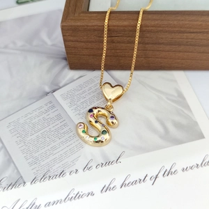 Detailed view of a gold S-letter heart pendant with multi-colored gemstones and chain