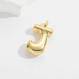 Macro view of a 3D bubble letter J pendant with high-shine gold-plated finish