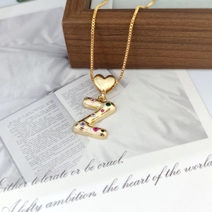 Detailed macro view of gold letter Z pendant featuring vibrant multi-colored gemstones