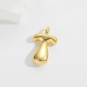 Close-up of golden balloon style letter T pendant with a polished mirror finish