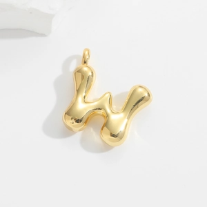 Macro view of a gold-plated chubby letter W balloon pendant with mirror-polished finish