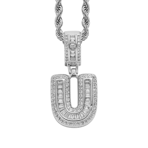 Macro detail of iced-out silver letter U pendant with cubic zirconia on a rope chain