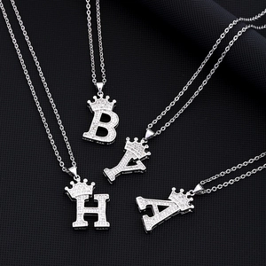 Macro shot of silver hip-hop crown letter pendants with sparkling zircon inlays