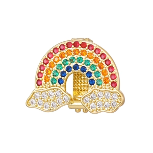 Detailed macro of a gold rainbow charm with colorful stones and sparkling white clouds