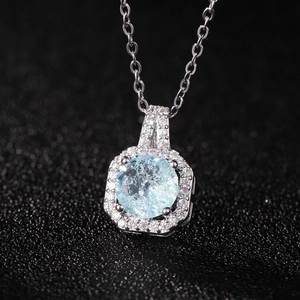 Vue macro d'un pendentif flacon de parfum avec zircon bleu clair et halo de diamants