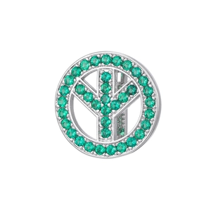 Detailed view of silver charm with pavé-set green emerald-cut stones and sleek finish