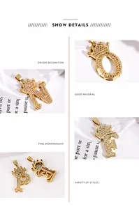 Detail view of gold letter pendants with crown motifs and micro-set cubic zirconia stones