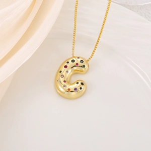 Détail d'un pendentif lettre C doré en 3D avec oxydes de zirconium colorés sur chaîne