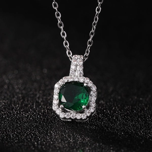 Gros plan macro d'un collier pendentif en zircon vert émeraude avec monture en argent