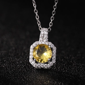 Gros plan du pendentif flacon de parfum de luxe avec zircon jaune et cristaux pavés