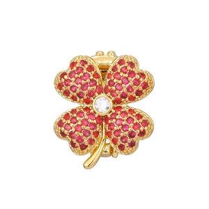 Macro detail of red clover charm with gold plating and cubic zirconia inlay