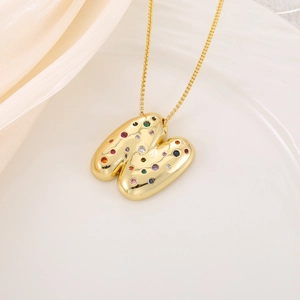 Détail du pendentif lettre M doré orné de zircons cubiques multicolores pavés