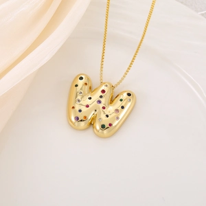 Détail du pendentif lettre W dorée style bulle serti de zircons multicolores brillants