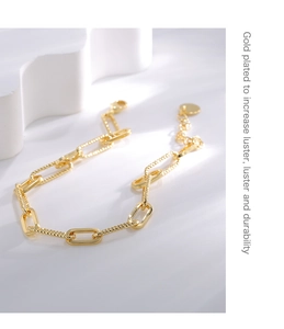 Gros plan du bracelet trombone plaqué or avec maillons texturés et fermoir mousqueton