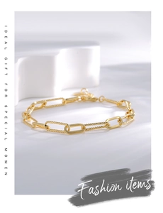 Détails du bracelet trombone doré montrant les maillons lisses et les textures torsadées