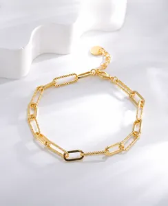 Détail d'un bracelet trombone plaqué or avec des maillons en métal texturés et lisses