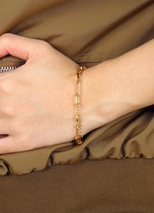 Gros plan du bracelet trombone plaqué or avec détails en cristal et chaîne de réglage