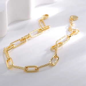 Bracelet chaîne trombone élégant plaqué or avec maillons texturés sur fond blanc