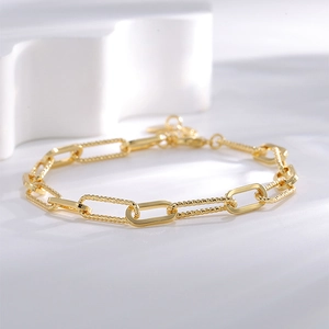 Bracelet trombone en laiton doré avec maillons polis et torsadés, fermoir ajustable