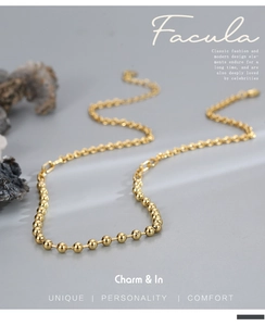 Detailed view of golden beaded necklace with linked chain and glossy metal finish