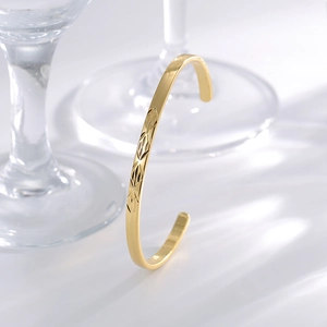 Gold-plated adjustable cuff bangle with geometric diamond cut patterns in high-gloss finish