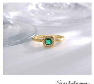 Close-up of gold-plated ring with a square green zircon and micro-inlaid detailing