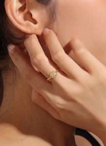 Macro detail of gold-plated ring featuring square yellow zircon and textured band