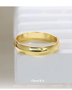 Dettaglio dell'anello minimalista placcato oro con superficie lucidata a specchio