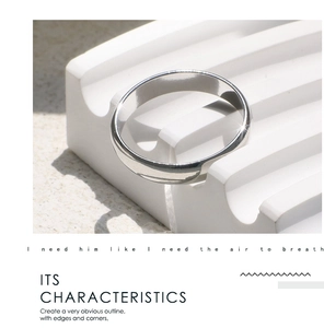 Dettaglio macro di un anello lucido minimalista su un espositore geometrico bianco puro