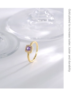 Detailed macro shot of gold-plated ring with square purple zircon and textured band