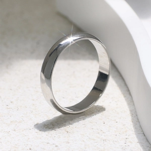 Anello minimalista lucido color argento su sabbia con raffinato effetto luce stellata