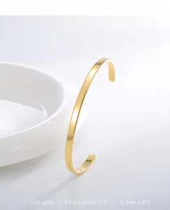 Détail macro du bracelet jonc ouvert doré poli montrant une texture métallique lisse