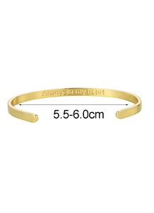 Gros plan d'un bracelet jonc doré avec la gravure Always in my heart à l'intérieur