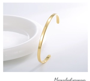 Détail montrant des zircons micro-incrustés sur un bracelet jonc doré poli