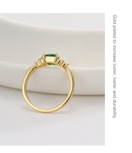 Dettaglio di un anello placcato oro con uno zircone verde smeraldo di forma rettangolare