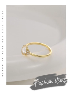 Detailed shot of golden ring with translucent round stone and small white zircon accents