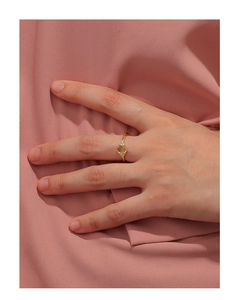 Detailed view of an elegant gold ring with oval gemstone and side zircons worn on hand