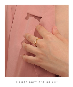 Detail of a vintage gold ring featuring a white cat-eye stone and small zircon accents