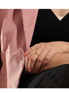 Detail of vintage gold ring featuring oval gemstone and side zircons on a model