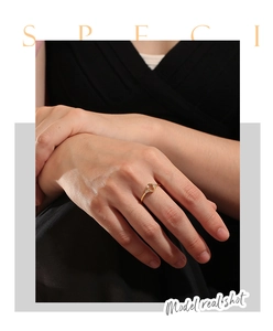 Detail of elegant gold ring with oval gemstone and small side diamonds on model's hand