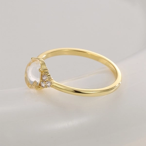 Elegant gold ring featuring a large oval gemstone and sparkling side zircon accents