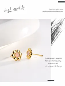 Detailed macro view of 18K gold plated floral stud earring with opal stone center